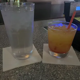 Glass of water and tequila sunrise