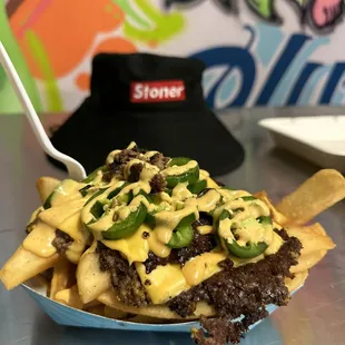 Smash burger fries (burger brisket, cheese, stoner sauce, jalepeños and pickles)