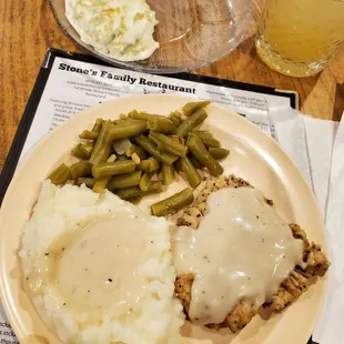 Chicken fried steak and mashed potatoes with gravy over all, green beans, Cole slaw.