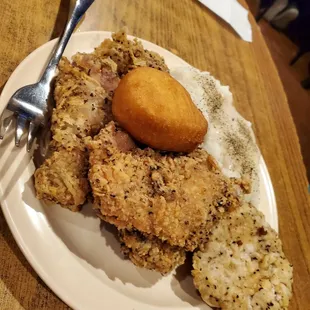 Fried chicken, chicken fried steak, mashed potatoes and gravy, fried biscuit on top.