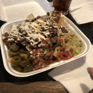a plate of nachos and a drink