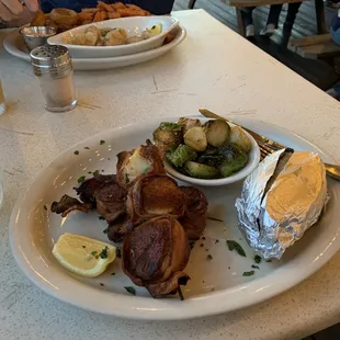 Bacon wrapped scallops, baked potato, and brussels sprouts