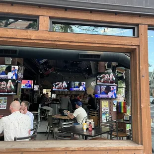 a group of people sitting at tables in front of a restaurant