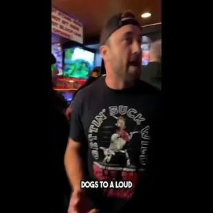 a man wearing a t - shirt that says dogs to a liquor