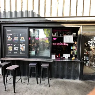 a storefront with two stools in front of it