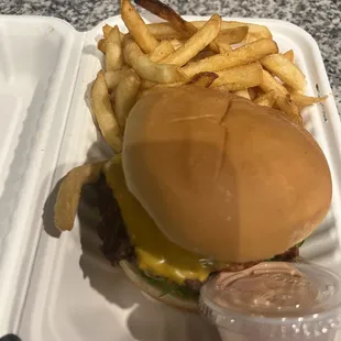 a hamburger and fries on a styrofoam container