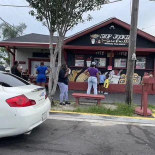 a group of people standing outside of a restaurant