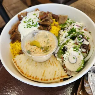 Gyro salad bowl with quarter slice of Peta bread.