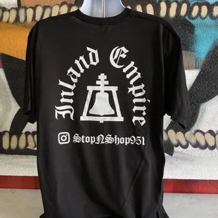 a black t - shirt with a bell on it