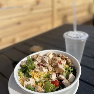 a bowl of salad and a drink