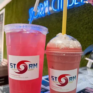 two drinks on a table with a neon sign in the background