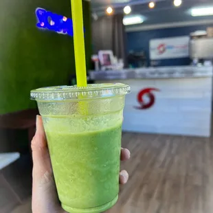 a hand holding a green smoothie