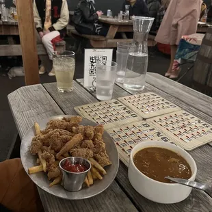 a plate of fried chicken nuggies and a bowl of gravy soup