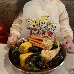 a woman holding a plate of seafood
