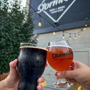 two people holding glasses of beer
