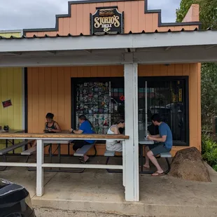 three people sitting at a picnic table