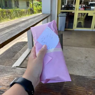 a hand holding a piece of paper with a note attached to it