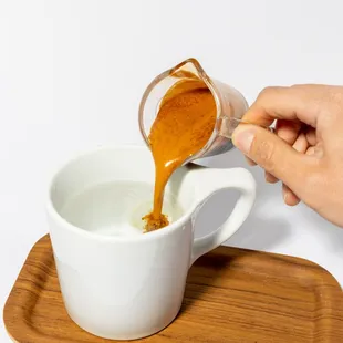 a person pouring caramel into a cup