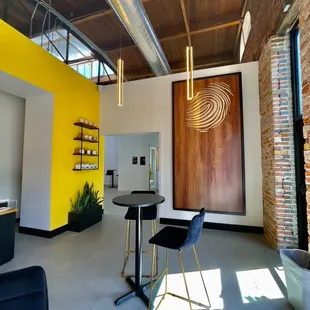 a yellow wall and a black table and chairs