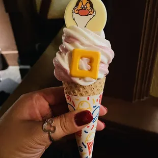 a hand holding a cone of ice cream