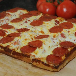 a pepperoni pizza on a cutting board