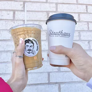 two hands holding a cup of coffee