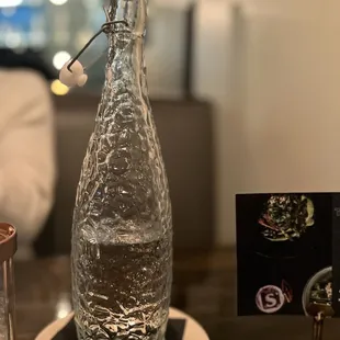 a glass bottle of water on a table