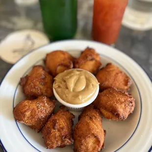 a plate of doughnuts with a dipping sauce