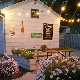 a small white building with flowers and lights