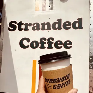 a hand holding a cup of coffee