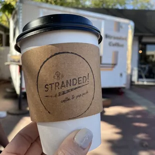 a hand holding a cup of coffee
