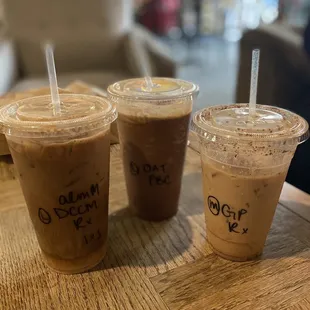 three cups of iced coffee on a table