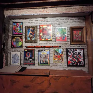 a brick wall with a bunch of paintings on it