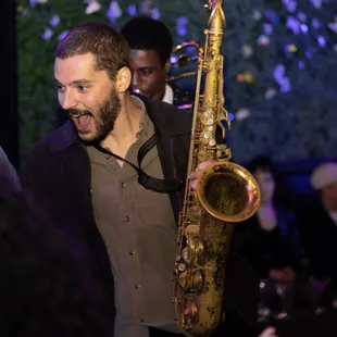 a man holding a saxophone in front of a crowd