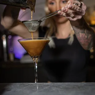 a female bartender pouring a drink