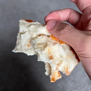a hand holding a piece of bread