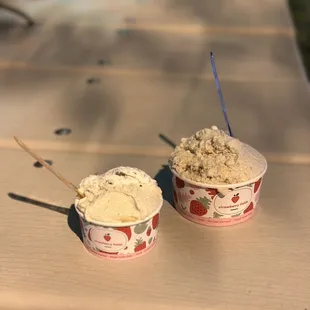 two cups of ice cream on a picnic table