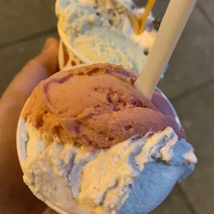 a hand holding two scoops of ice cream