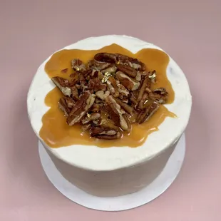 A sweet twist on a classic banana cake. Banana cake with cream cheese frosting, salted caramel and buttered pecans. Serves 3-5 people