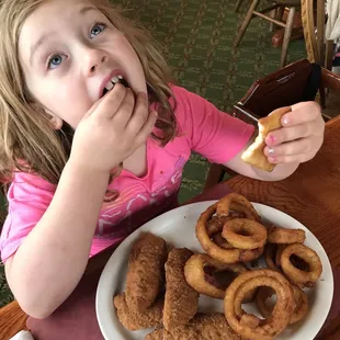 a young girl eating donuts
