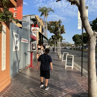 a little boy walking down the sidewalk