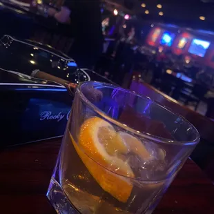 a drink in a glass with a slice of lemon