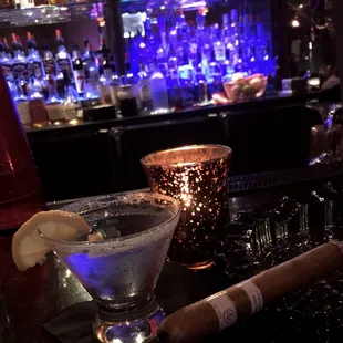 a martini and cigar on a bar counter