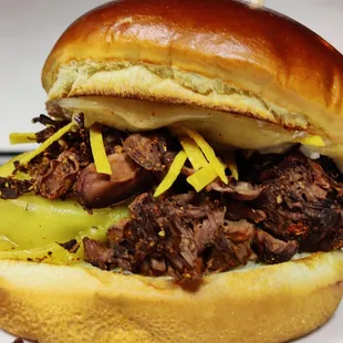 a beef sandwich with cheese and pickles