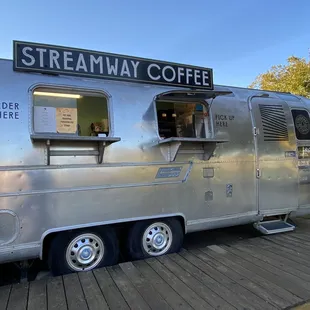a coffee truck parked on a wooden platform