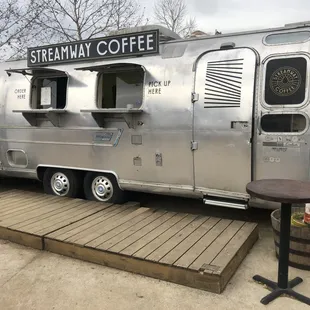 a coffee trailer parked on a wooden platform