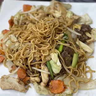 a plate of noodles with meat and vegetables