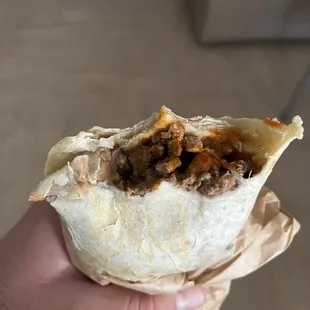 a hand holding a burrito