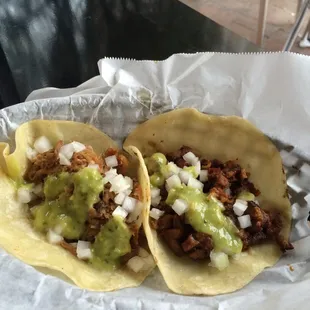 One al pastor taco and one carnitas taco