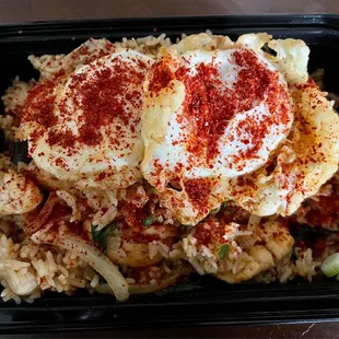 Chicken spicy basil fried rice with two fried eggs and covered in chili